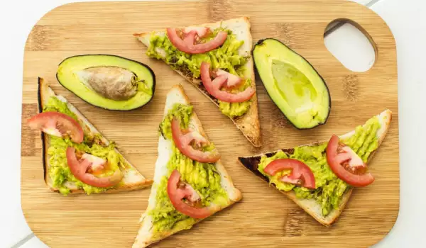 Avocado auf einer Brotscheibe verteilen